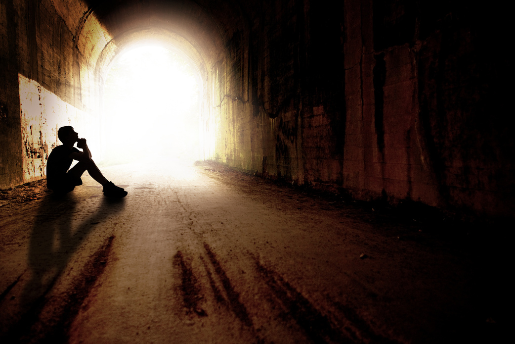 Silhouette of Teen in Praying in Dark Tunnel